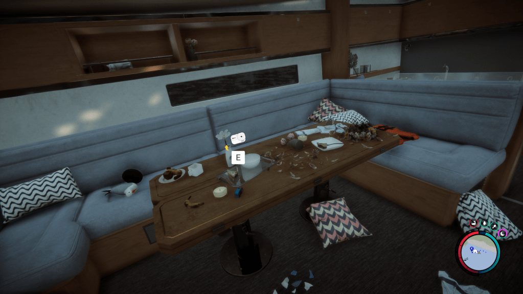 Video camera sitting on a messy table inside the cabin of a sailboat.